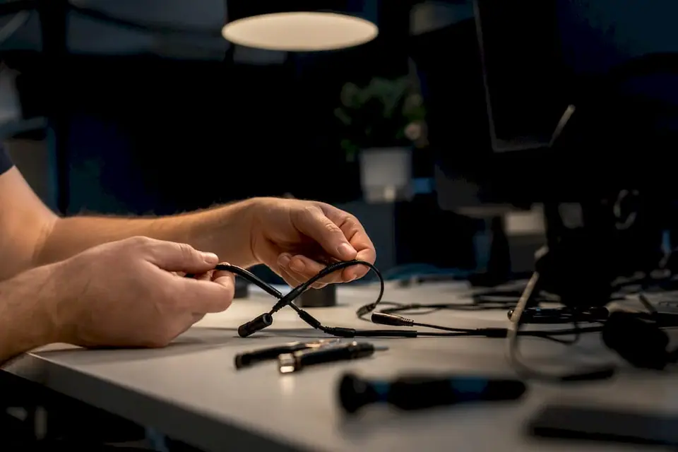 Hände, die die Kabel eines Callcenter-Headsets verbinden