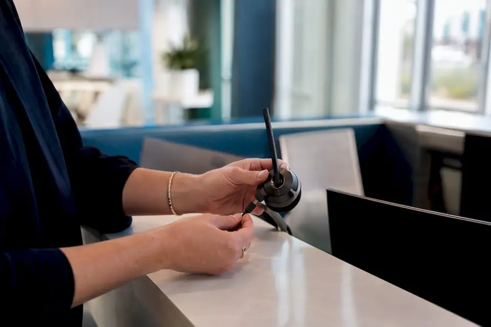 Hände schließen ein sicheres Callcenter-Headset an
