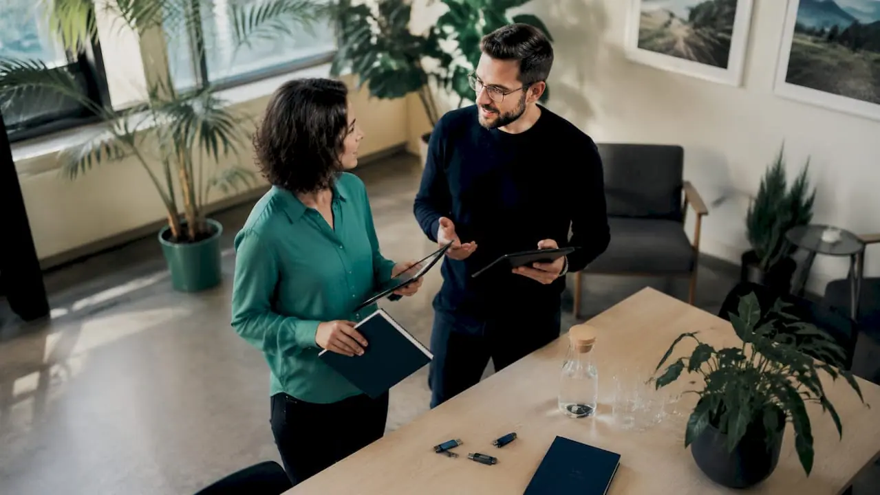 Zwei IT-Experten unterhalten sich über die Vor- und Nachteile von Middleware-Lösungen im Vergleich zur direkten Systemanbindung.