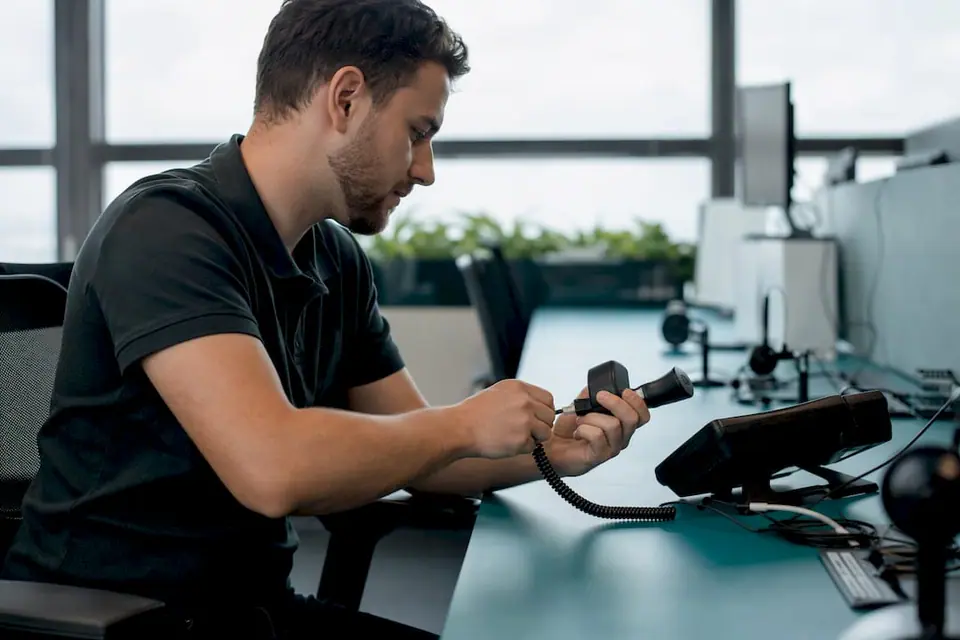 Hände, die das Headset-Kabel im Callcenter anschließen
