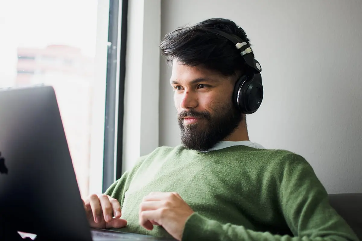 Kundenservice-Agent mit Headset bei der Arbeit am Laptop